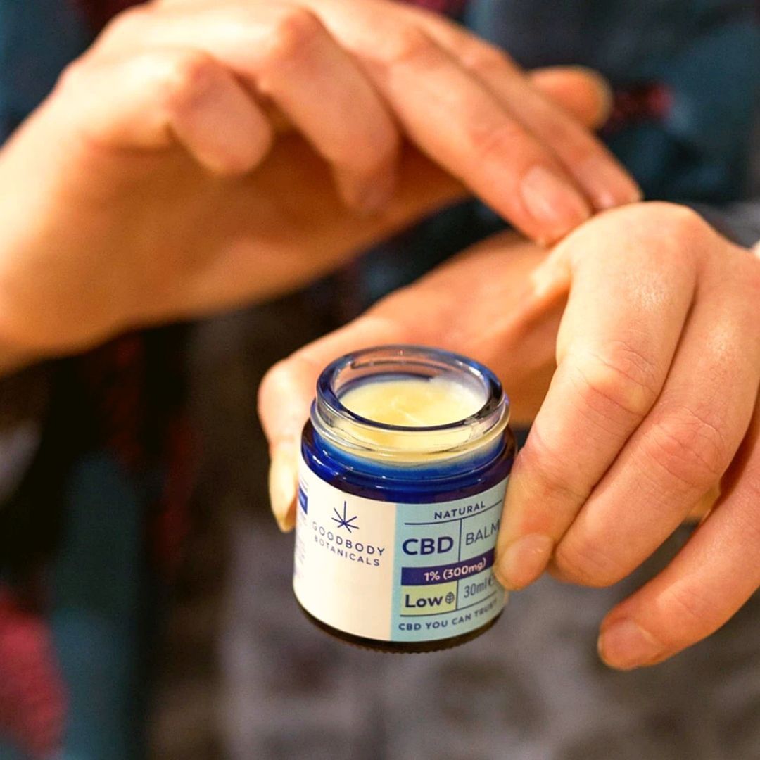 pair of hands applying cbd balm by Goodbody