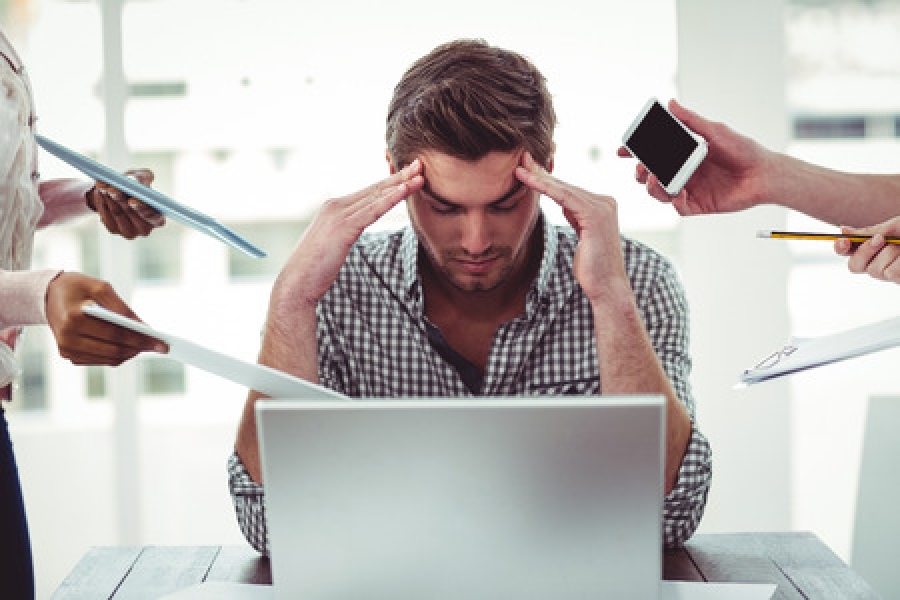 Man suffering from stress with people pressuring him with work